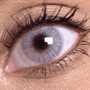 Before and after transformation using Solotica Hidrocor Rio Parati grey-blue contact lenses on dark brown eyes.